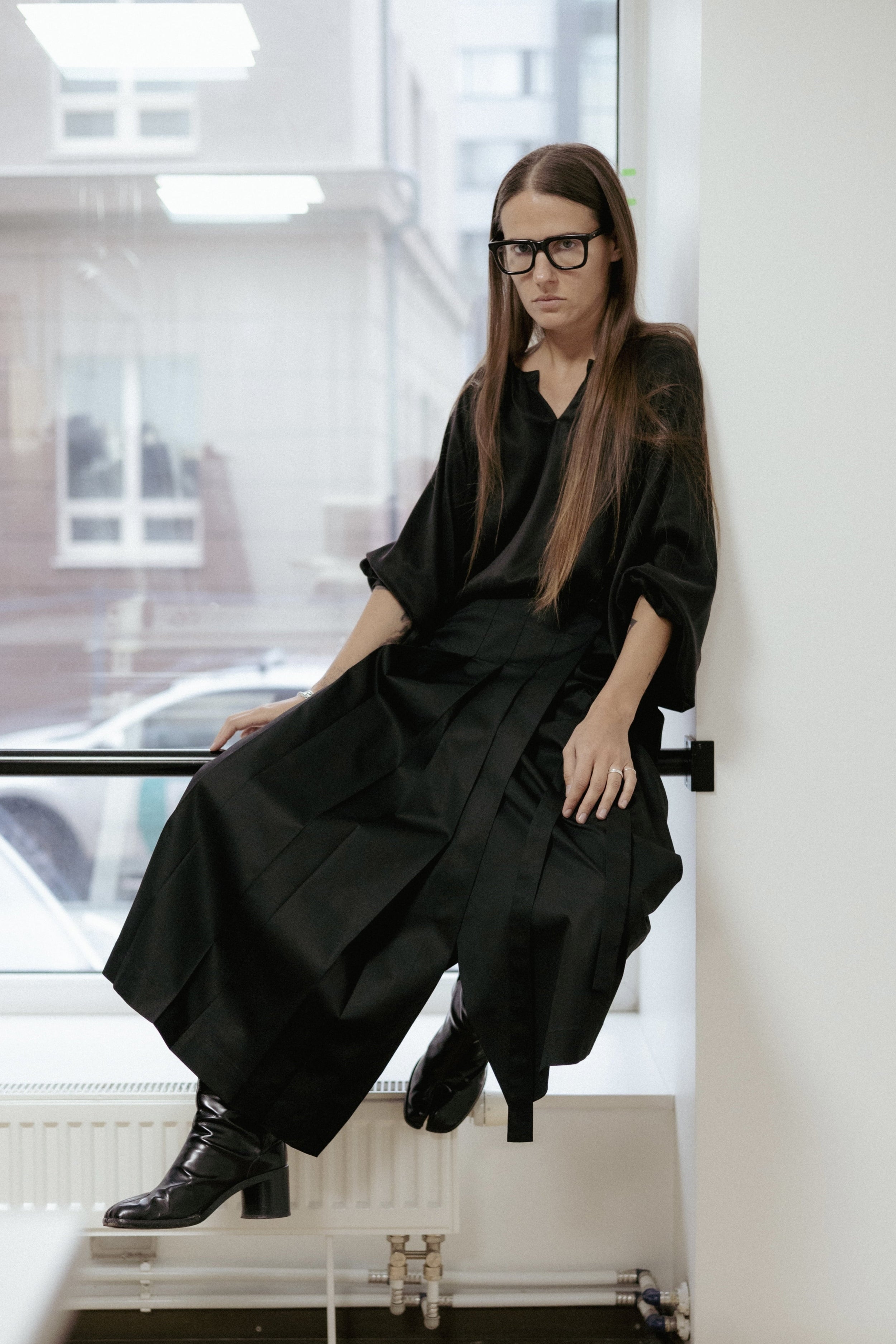 Black cotton wrap skirt with pleated front and adjustable tie. Soft structure, mid-length, and easy care. Made in Estonia.