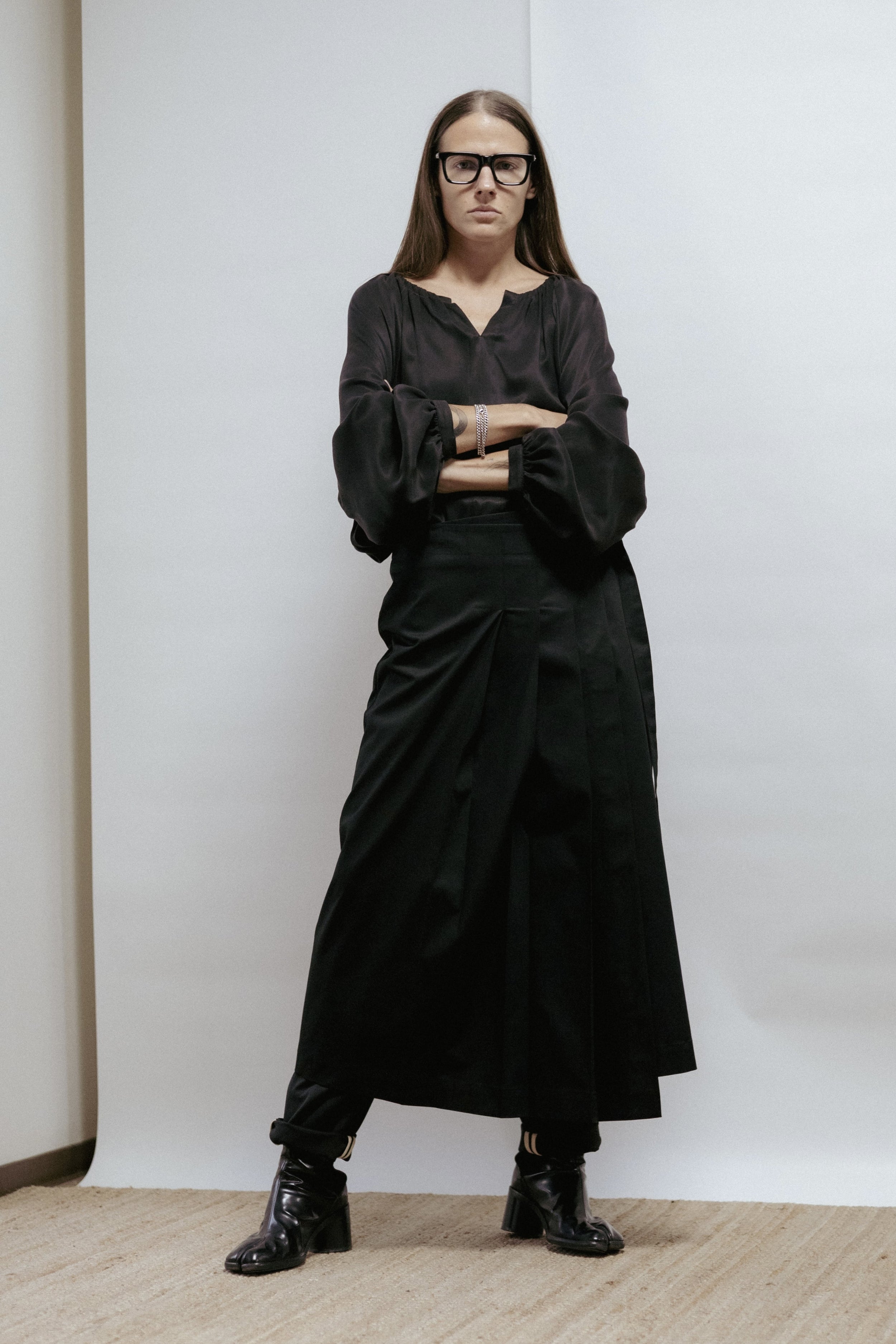 Black cotton wrap skirt with pleats and tie fastening. Adjustable fit, midi length, and machine washable. Made in Estonia.