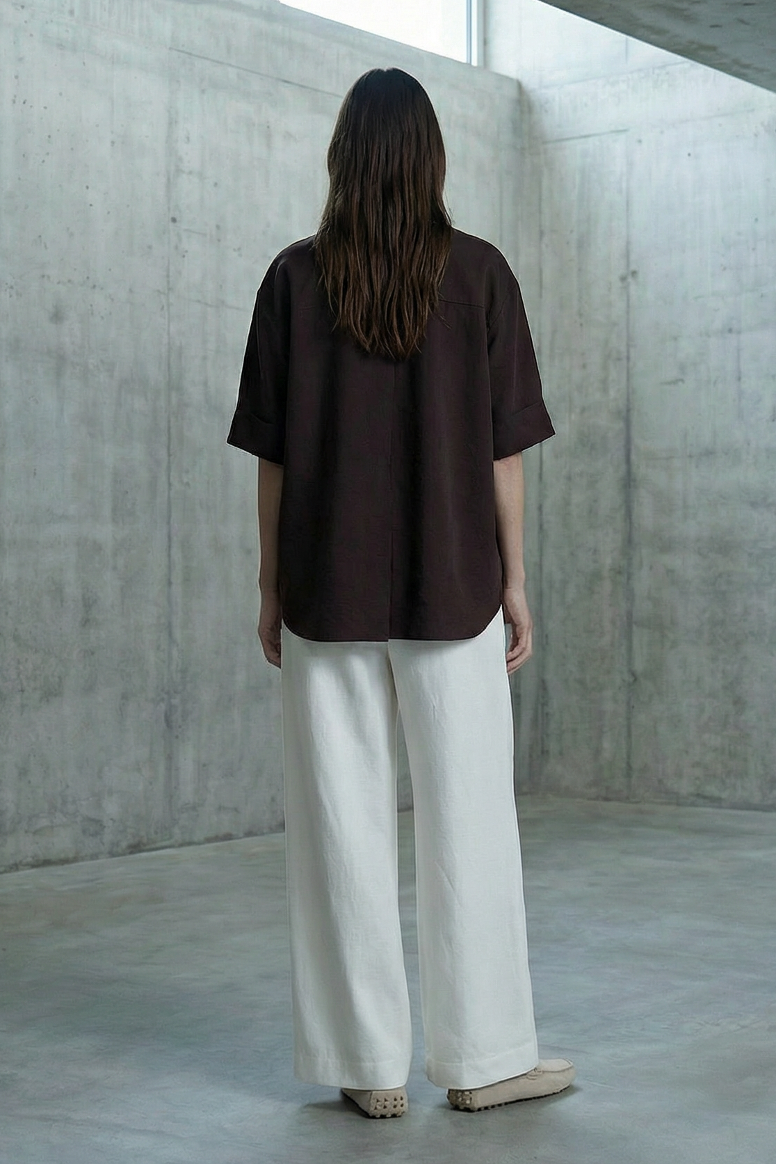 Person standing in a minimalist concrete room