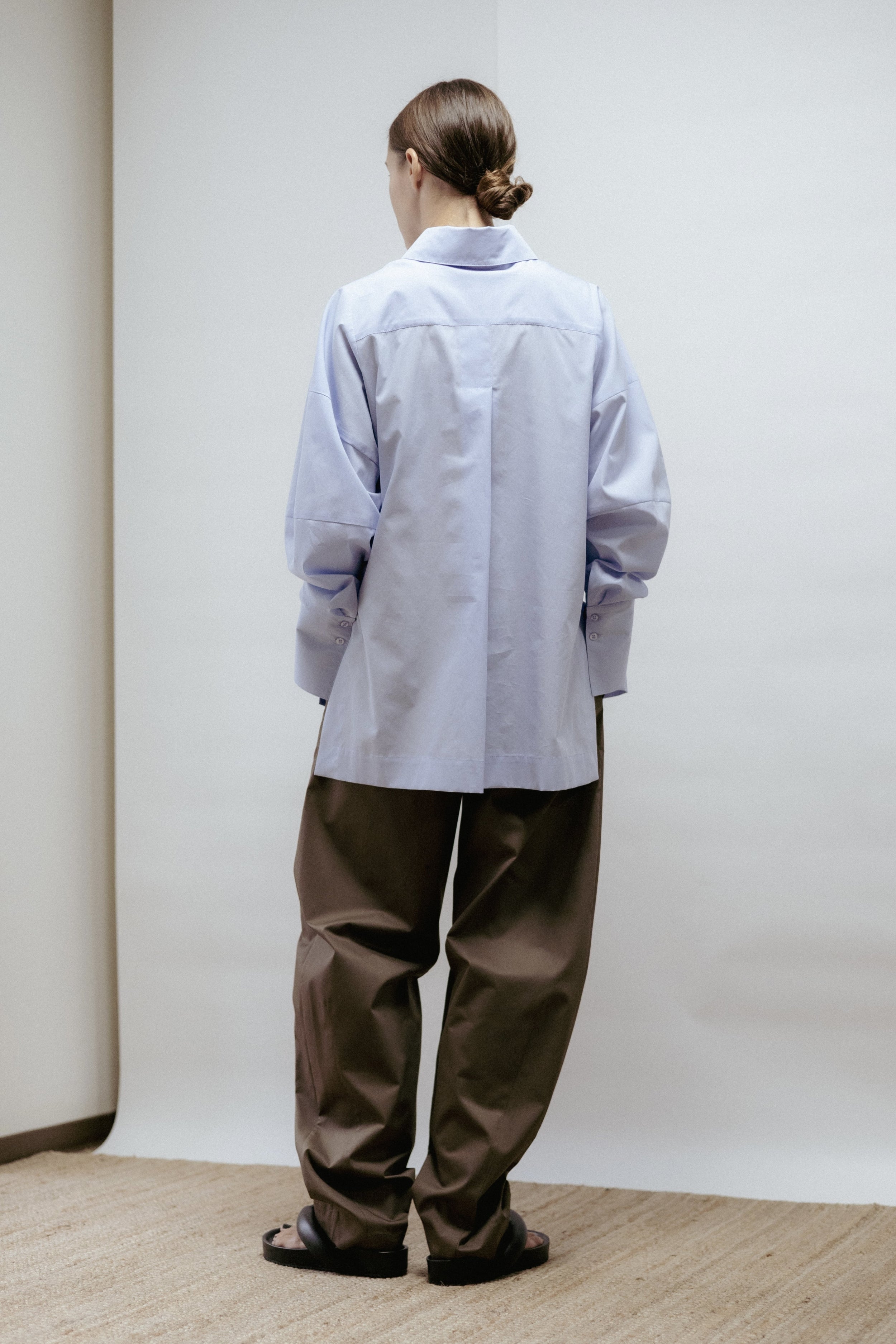 Light blue cotton blouse with wide cuffs and sculptural sleeves. A minimalist design made in Estonia — refined, versatile, and designed to last.