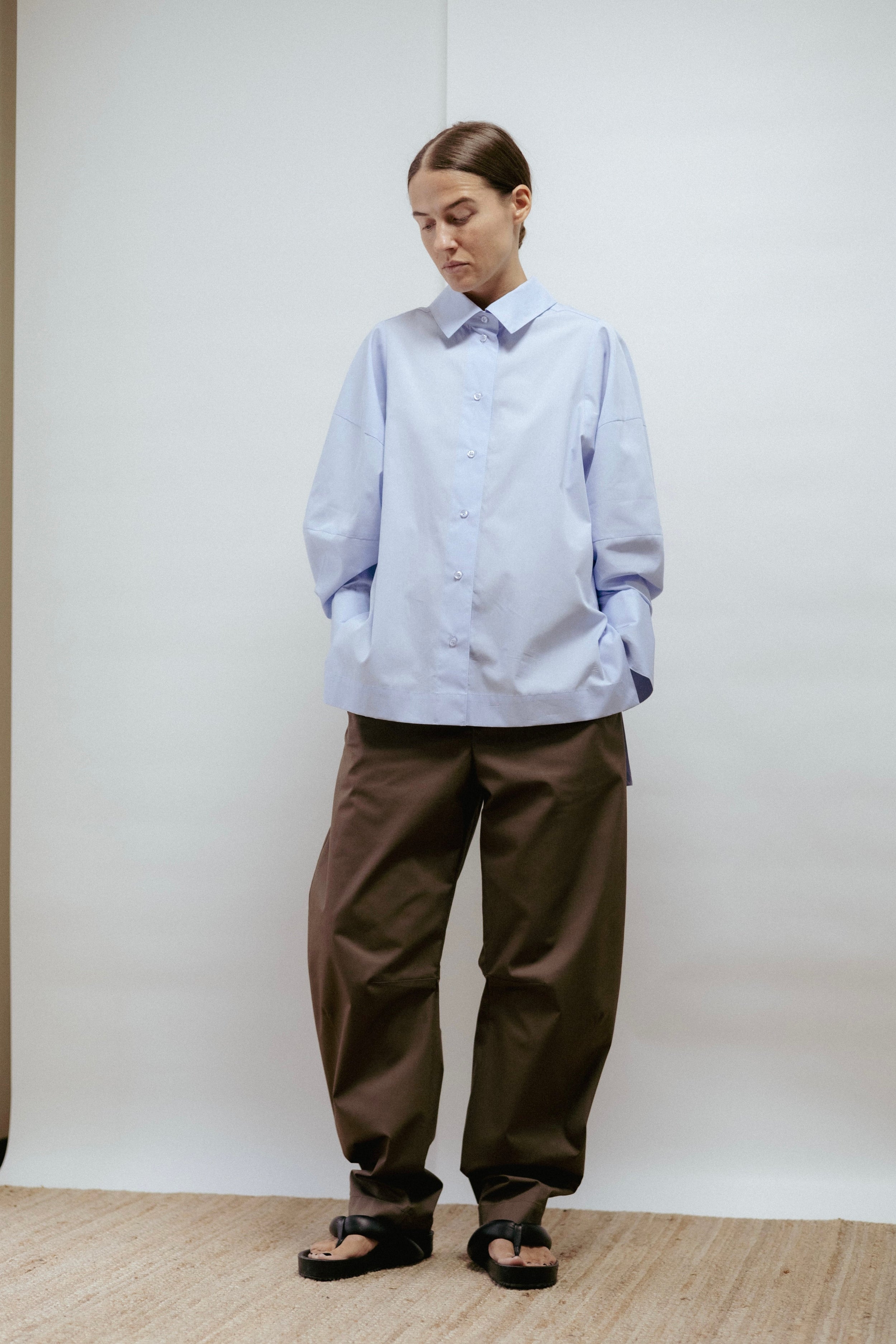 Light blue cotton blouse with flared sleeves and wide cuffs. Ethically made in Estonia, perfect for work or evening wear.