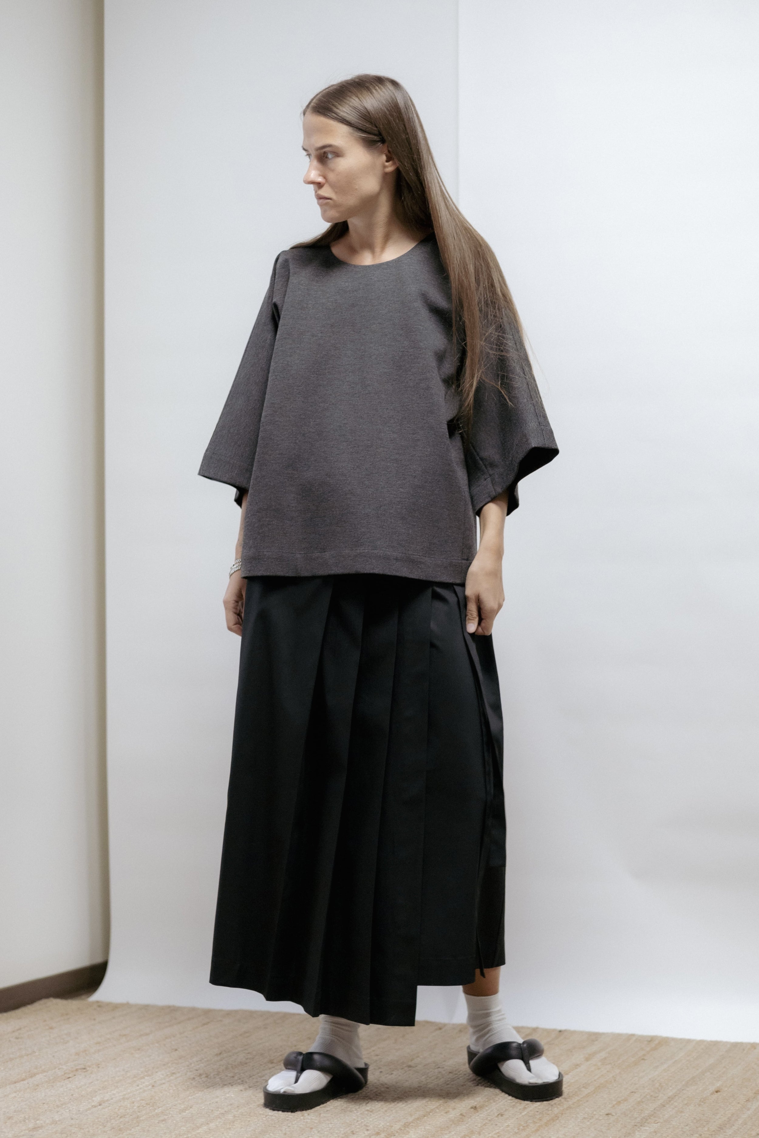 Black cotton wrap skirt with pleated front and adjustable tie. Soft structure, mid-length, and easy care. Made in Estonia.