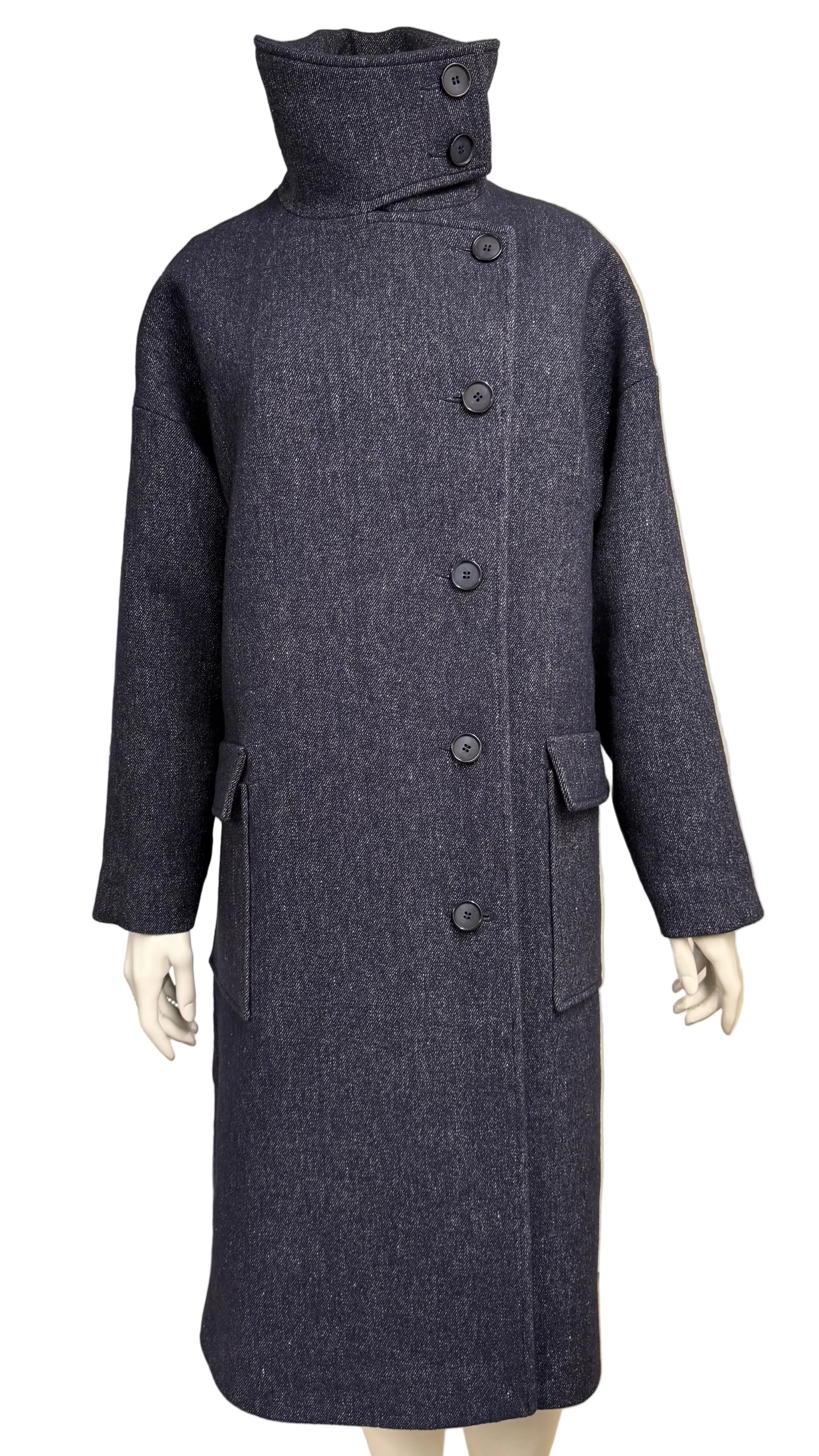 A dark charcoal gray textured wool coat with a high mock neck and button closure, displayed on a mannequin in an indoor showroom setting.