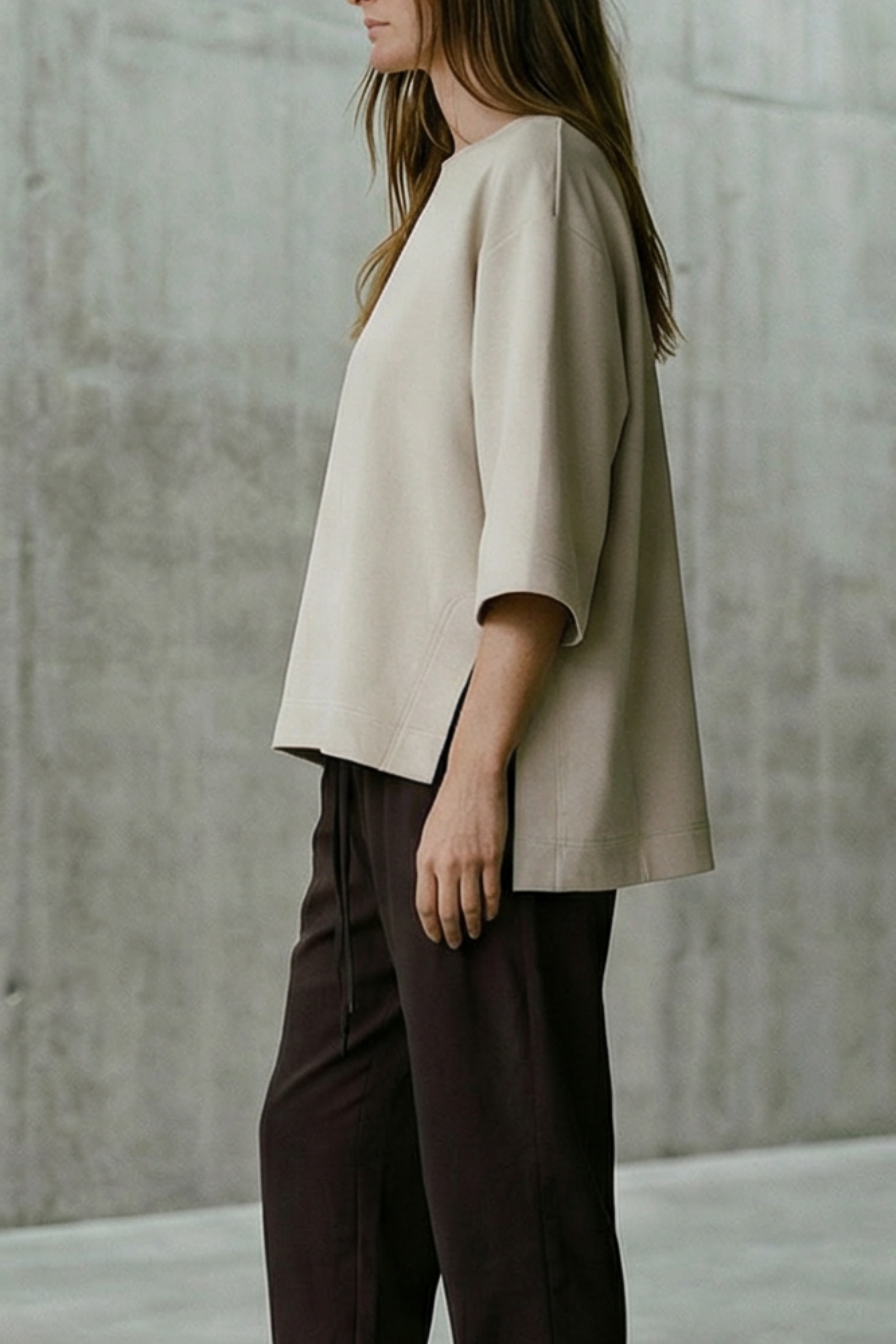 Person standing in a minimalistic room with concrete walls and floor.