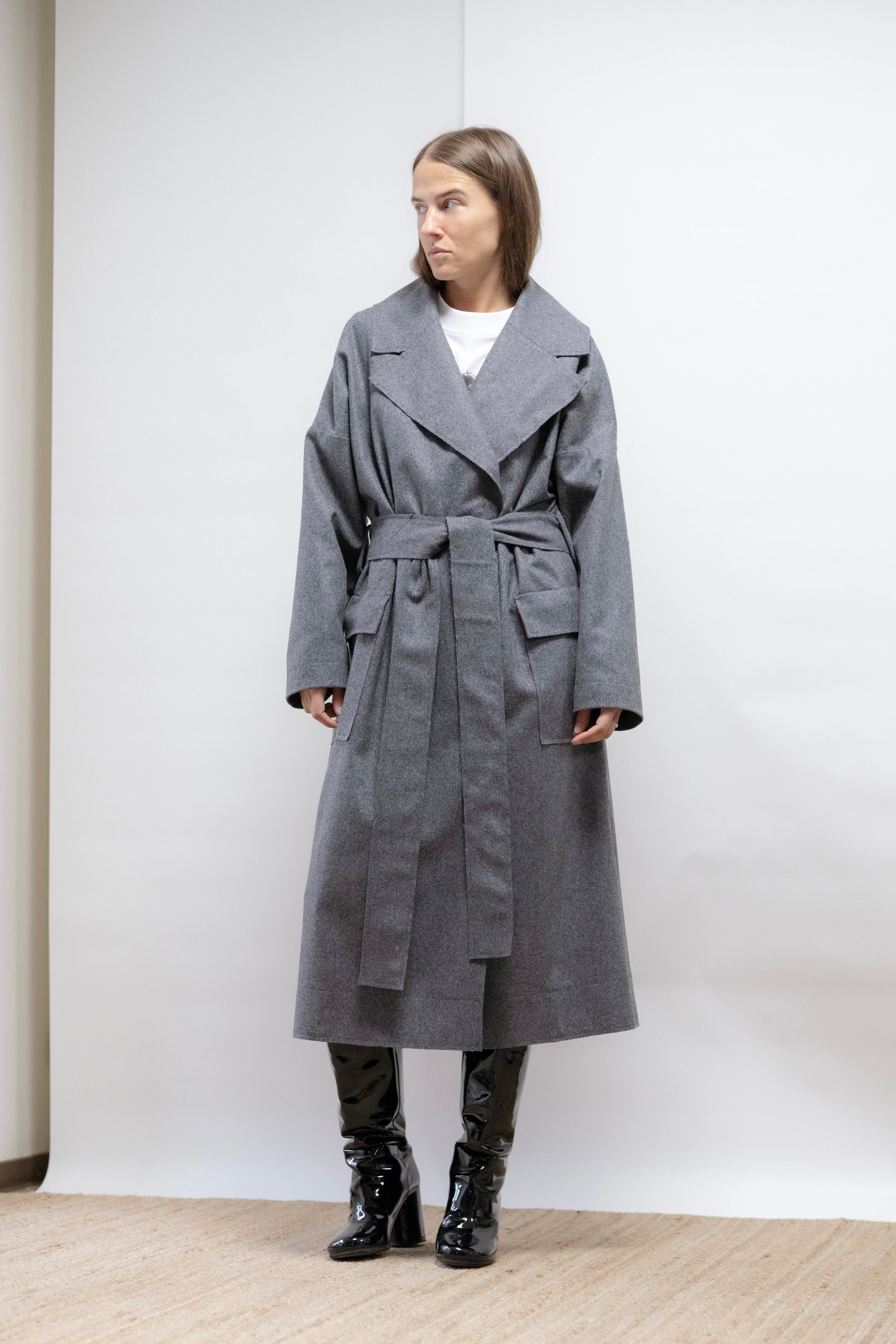 Minimalist grey wool coat with raw edges, cotton-lined sleeves, and a relaxed silhouette. Refined, warm, and effortlessly elegant.
