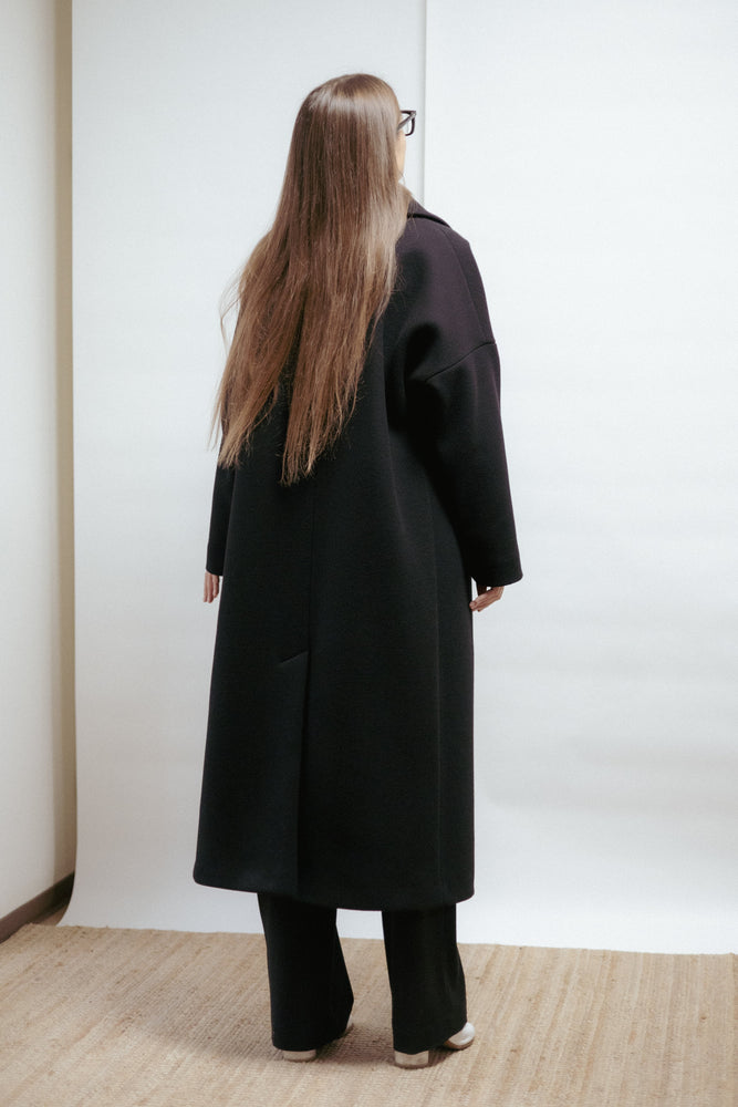 Black wool coat with wide lapel and relaxed shape. Modern elegance and lasting warmth. Made in Estonia.