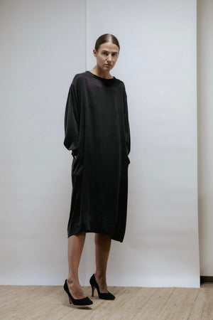 Black cupro dress with boat neckline, long sleeves, and raw-cut edges. Relaxed fit, made in Estonia.