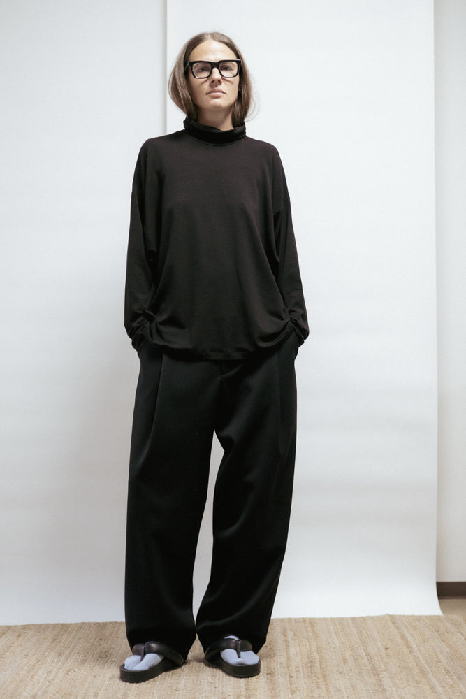 Black merino jersey top with high collar and kimono sleeves. Soft, warm, and versatile. Made in Estonia — minimalist design for timeless wear.