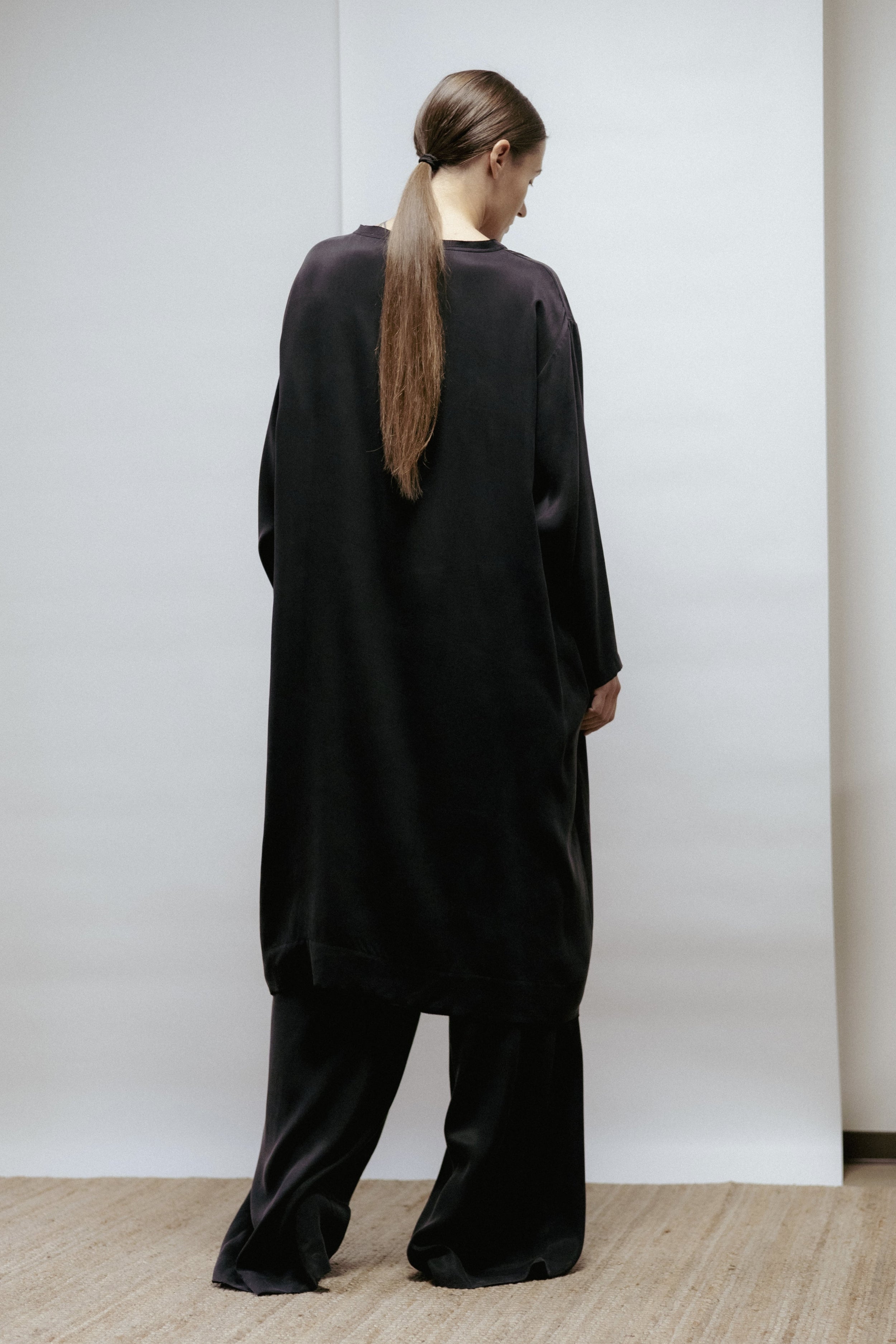 Straight black cupro-viscose dress with boat neckline and raw-cut edges. Can also be worn as a tunic with matching trousers. Made in Estonia.