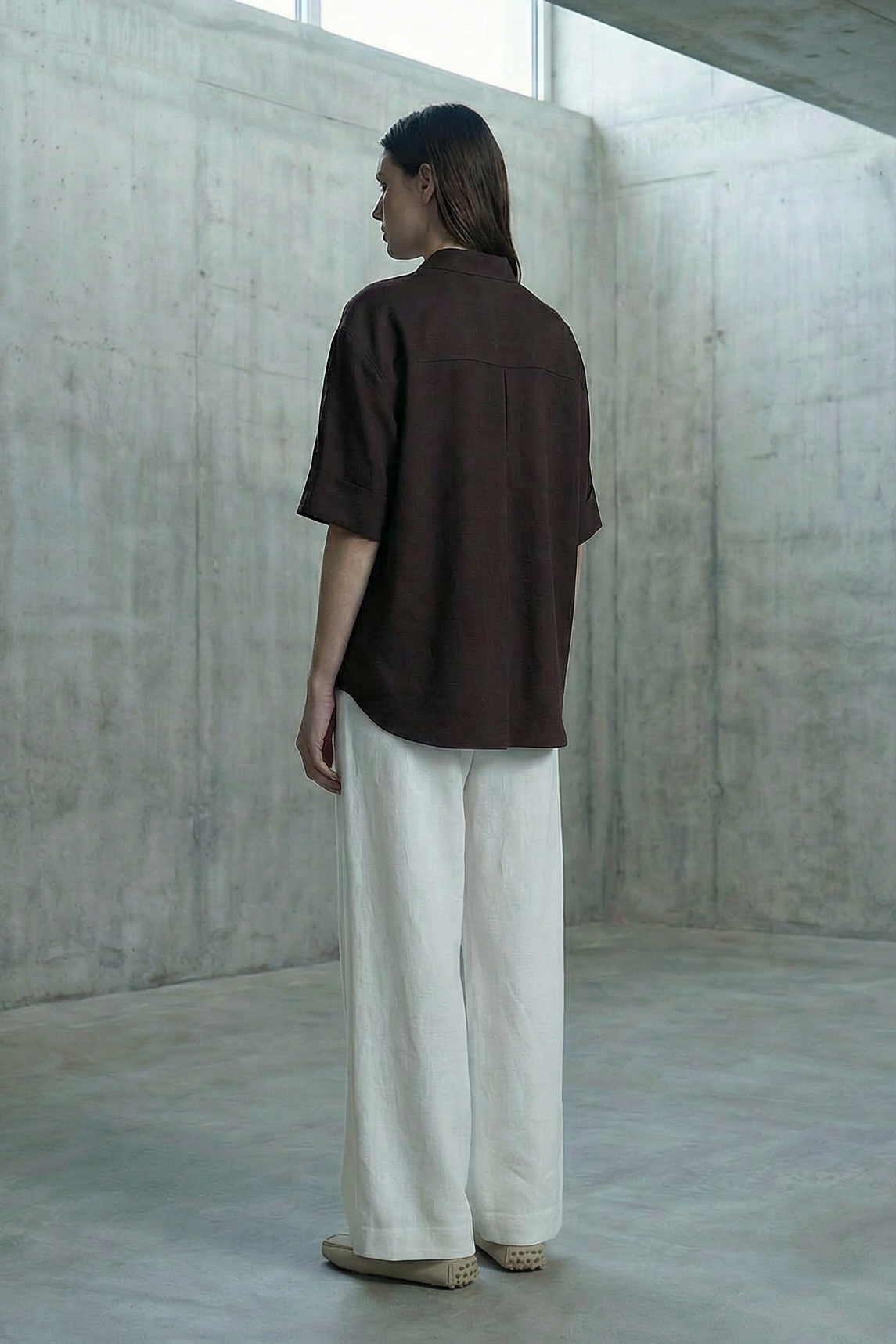 Person standing in a minimalist concrete room