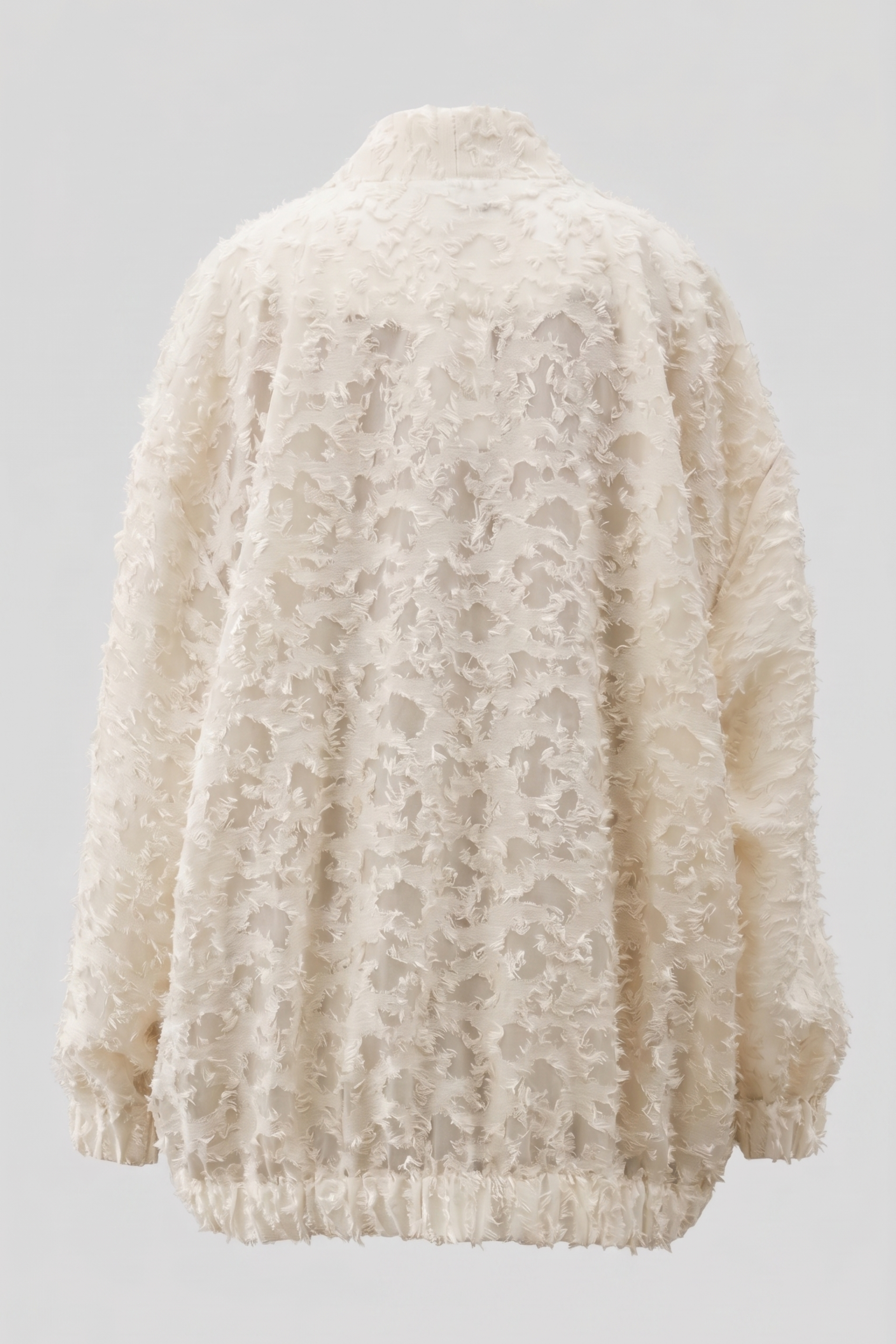 An oversized cream-colored textured jacket with a high mock neck, long sleeves, and a frayed hem, shown from the back against a light gray background.