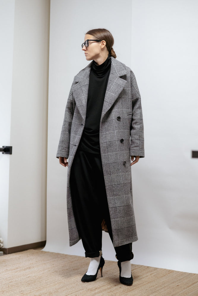 Checked wool coat with large lapel collar and relaxed fit. Midi length, warm lining, and subtle structure. Made in Estonia.