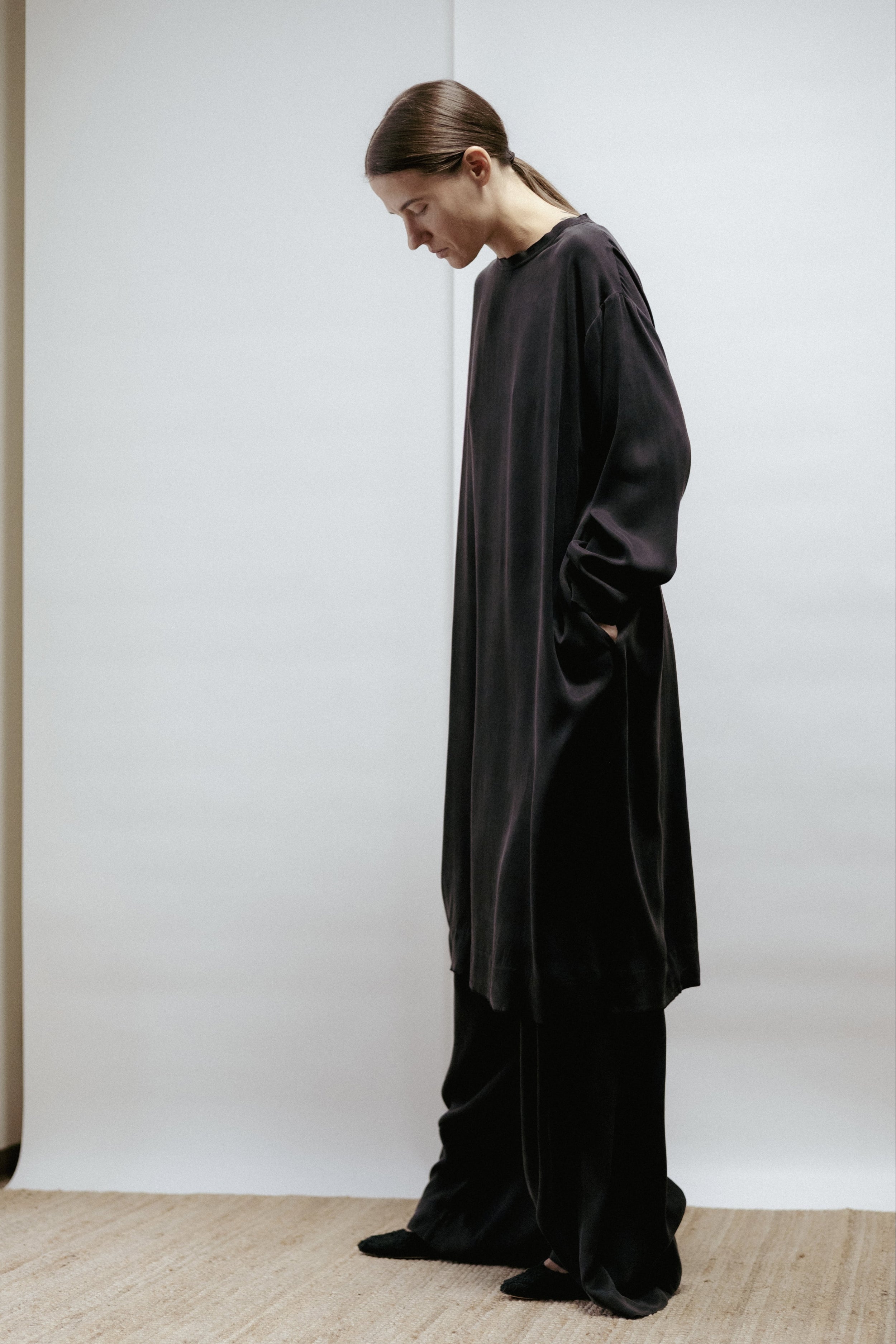 Black cupro dress with boat neckline, long sleeves, and raw-cut edges. Relaxed fit, made in Estonia.