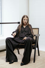 Black cotton wrap skirt with pleats and tie fastening. Adjustable fit, midi length, and machine washable. Made in Estonia.