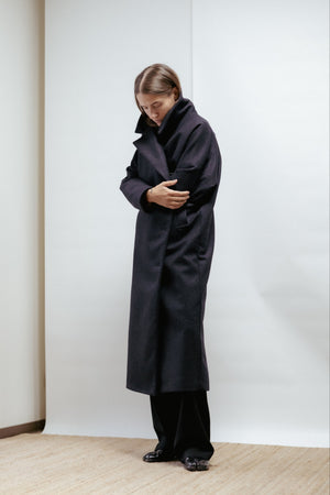 Dark grey wool coat with a wide lapel collar and slanted pockets. Straight, relaxed fit with back vent and light lining. Made in Estonia.