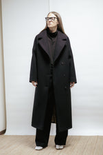 Black wool coat with wide lapel collar and relaxed fit. Midi length, warm lining, and refined simplicity. Made in Estonia.