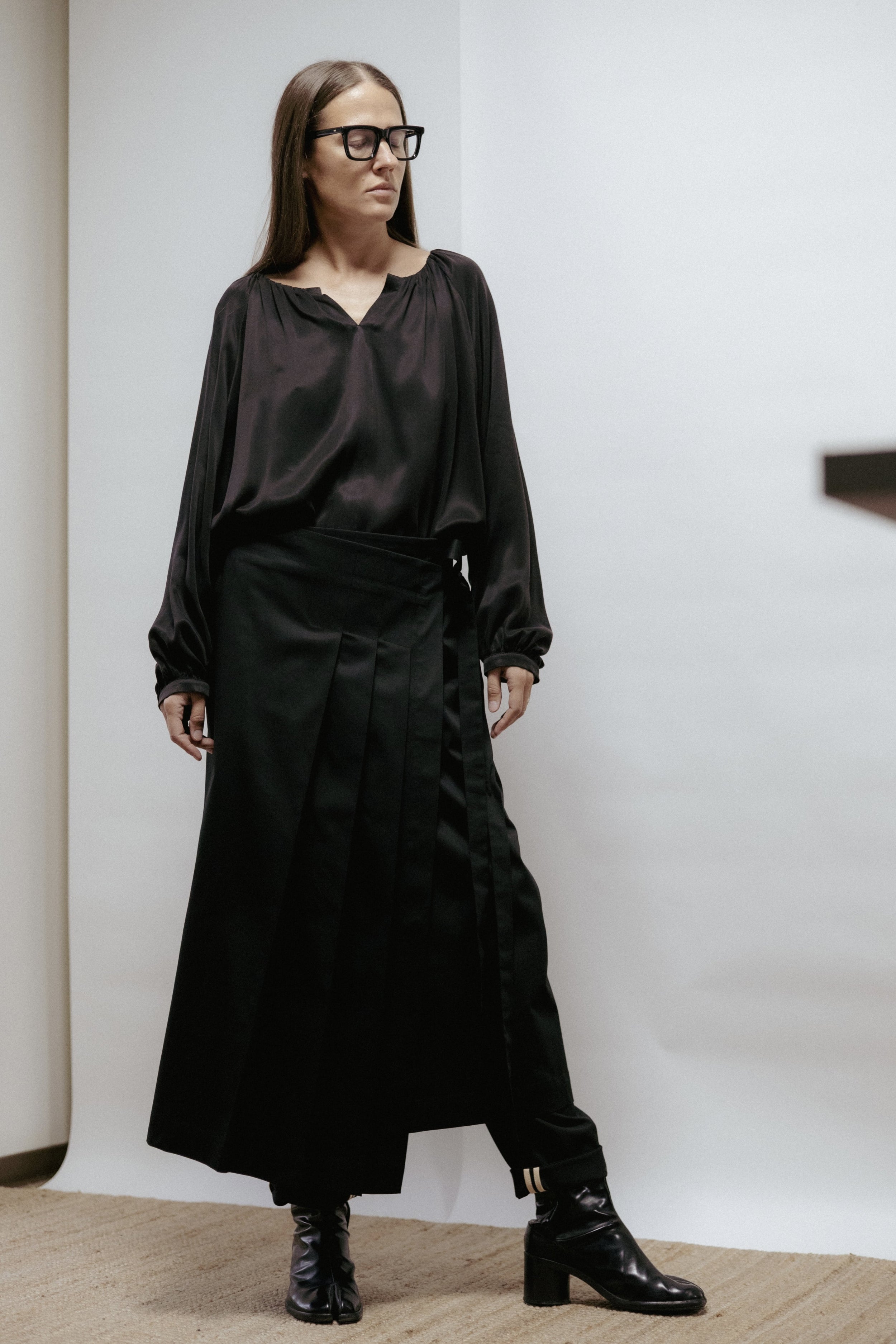 Black cotton wrap skirt with pleats and tie fastening. Adjustable fit, midi length, and machine washable. Made in Estonia.